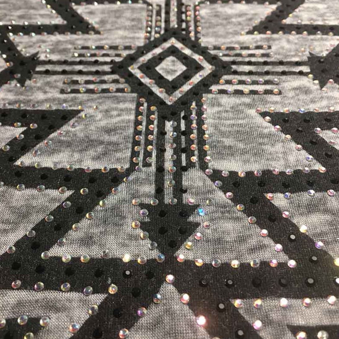 Primer plano de los motivos geométricos y las piezas de strass de colores en la camiseta Lana.