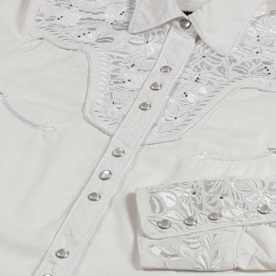 Primer plano de los bordados y ribetes de cordón de la camisa country Hailey.